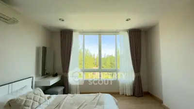 Bright bedroom with large window offering scenic view, modern decor, and cozy ambiance.