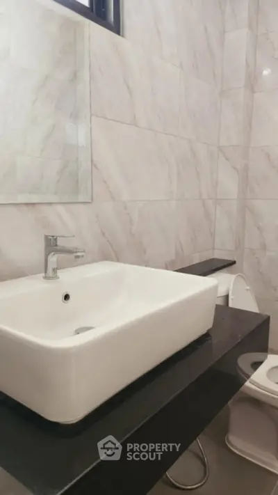 Modern bathroom with sleek sink and marble tiles