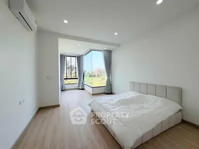 Spacious bedroom with large windows offering stunning views and natural light.