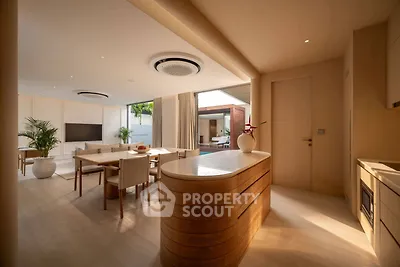 Luxurious open-plan living room with modern kitchen and outdoor view, perfect for entertaining.