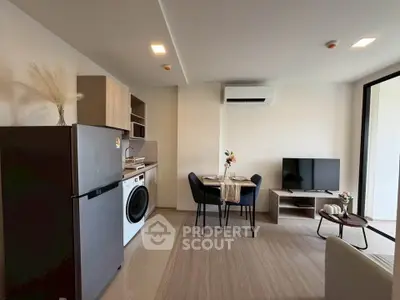 Modern living room with open kitchen, featuring sleek appliances and stylish decor, perfect for urban living.