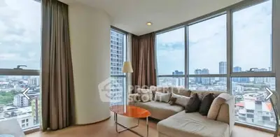 Spacious corner unit living room with panoramic city views and modern furnishings.