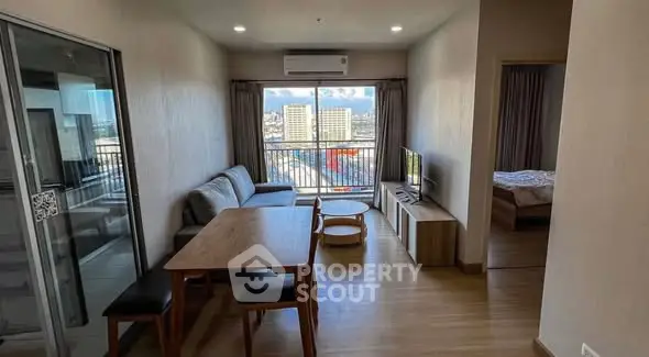 Modern living room with balcony view and cozy furniture setup.