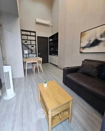Modern living room with high ceiling, stylish furniture, and contemporary decor in a cozy apartment.