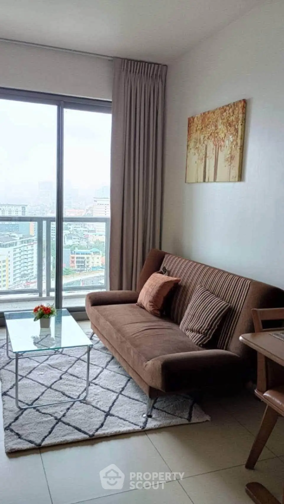 Chic living room with city view, cozy sofa, and modern decor in high-rise apartment.