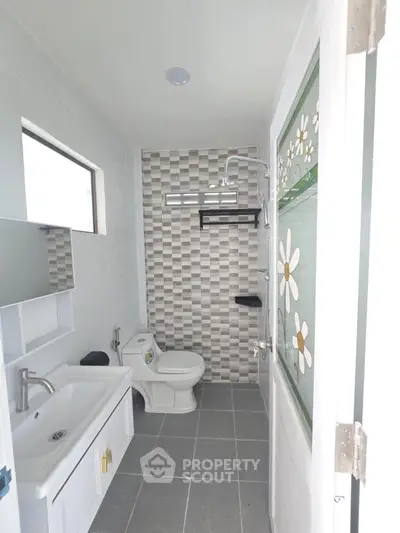 Modern bathroom with stylish tiles and sleek fixtures in a contemporary home.