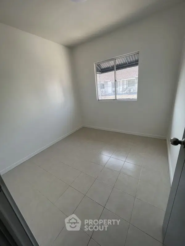 Minimalist empty room with tiled floor and window, perfect for customization.