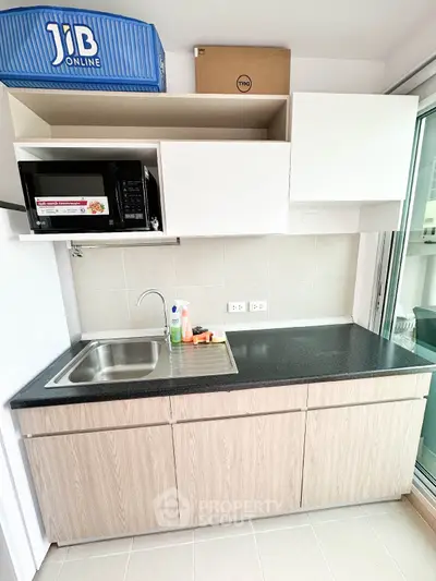 Modern kitchen with sleek cabinetry and built-in microwave, perfect for urban living.