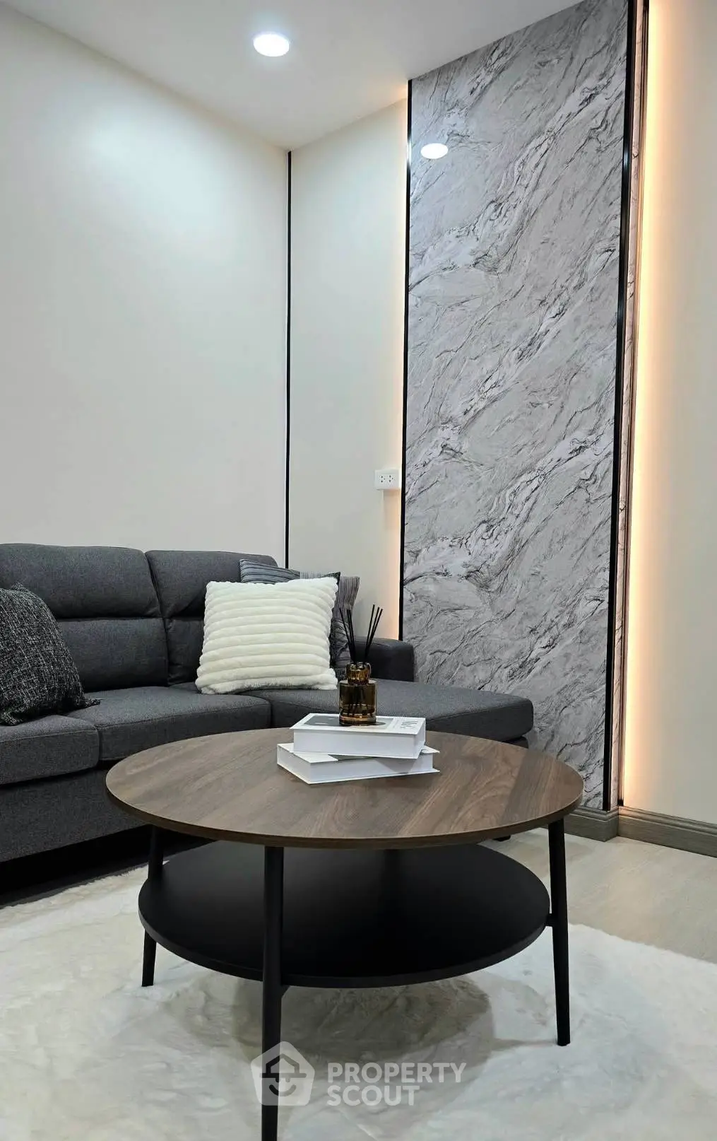 Modern living room with stylish gray sofa and elegant marble accent wall