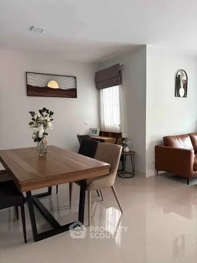 Modern dining area with elegant wooden table and stylish chairs in a bright, open living space.