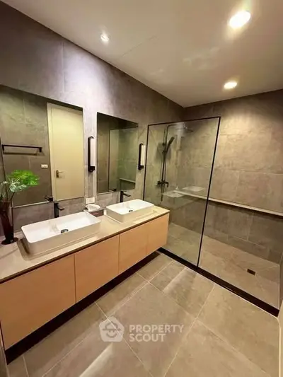 Luxurious modern bathroom with dual sinks and glass shower enclosure