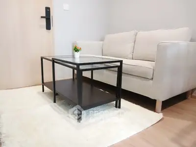 Modern living room with cozy beige sofa and sleek glass coffee table on plush rug.