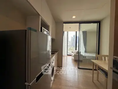 Modern apartment kitchen with open layout and city view from balcony