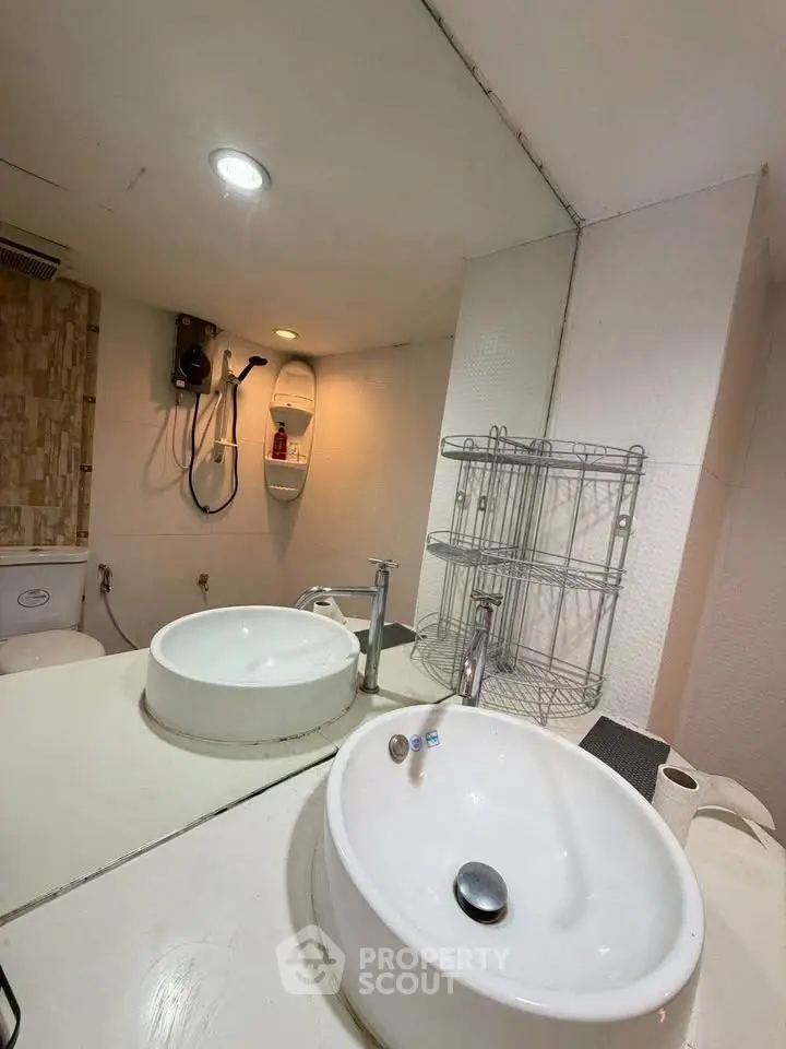 Modern bathroom with sleek fixtures and spacious design, featuring a large mirror and elegant sink.
