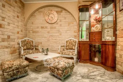 Charming vintage living room with floral furniture and elegant stone walls.