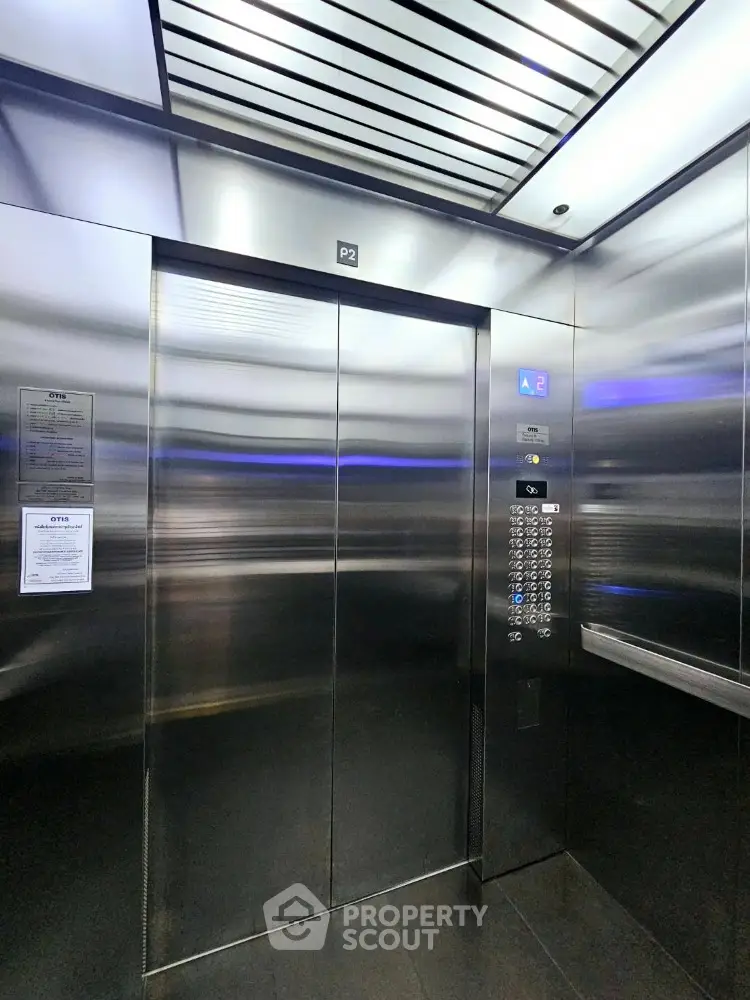 Modern stainless steel elevator interior with sleek design and advanced control panel