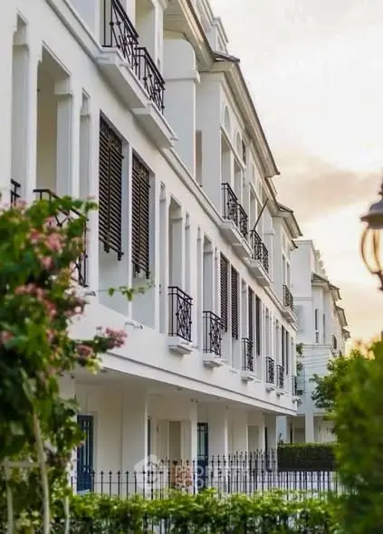 Elegant white building with classic architecture and lush greenery