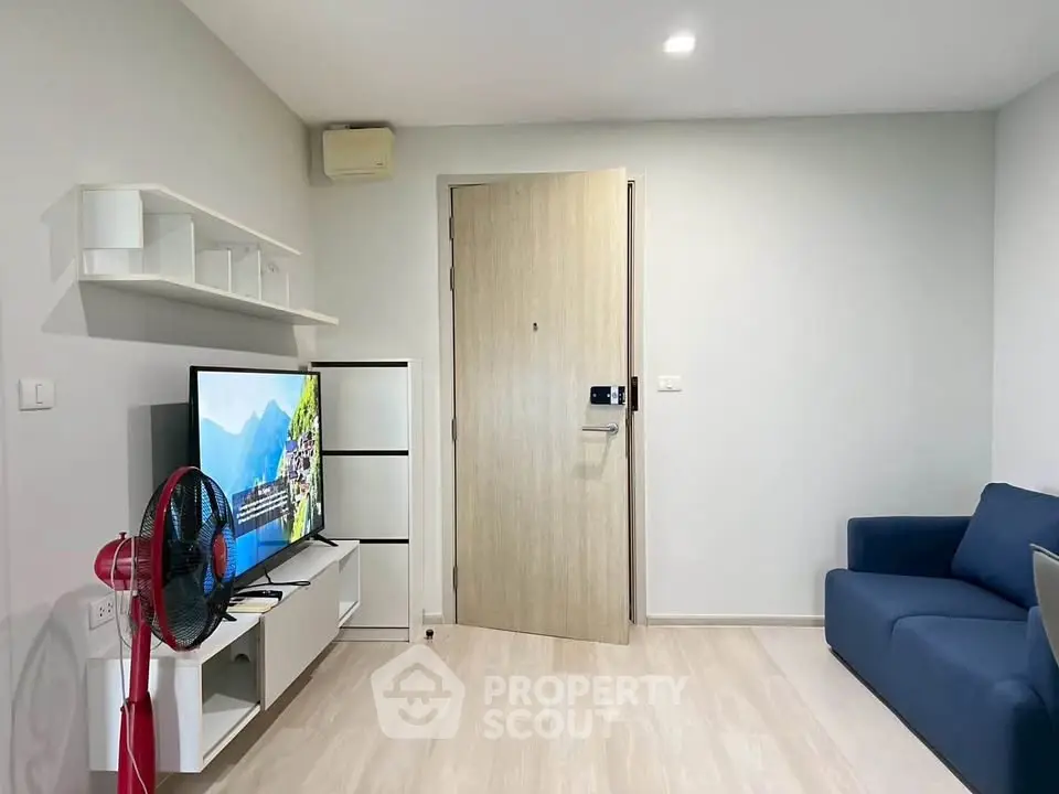 Modern living room with sleek furniture and flat-screen TV, showcasing minimalist design and cozy ambiance.