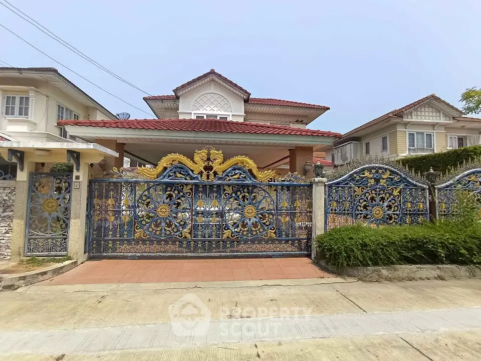 Elegant suburban house with ornate wrought iron gate and red-tiled roof