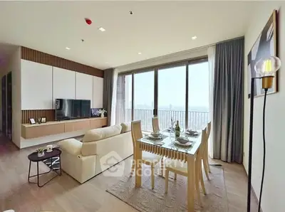 Modern living room with dining area and large windows offering stunning city views.