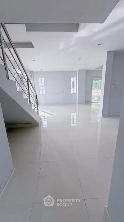 Spacious modern interior with sleek staircase and glossy white tiles