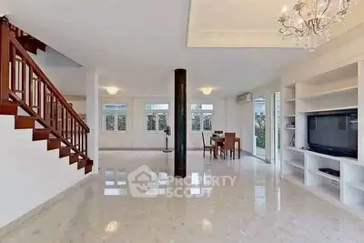 Spacious open-plan living room with elegant staircase and modern decor