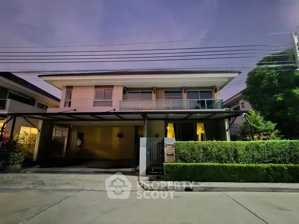 Modern two-story house with spacious driveway and lush greenery at dusk.