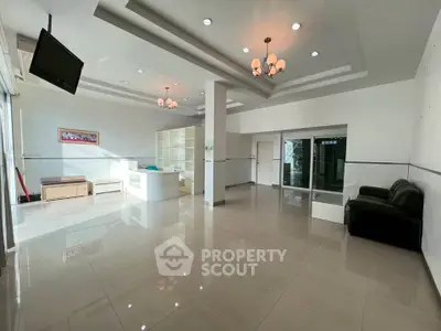 Spacious modern living room with elegant lighting and sleek tile flooring, perfect for contemporary living.