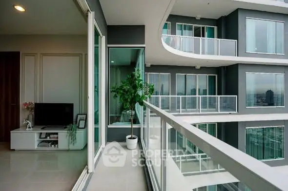 Modern apartment with spacious balcony and city view, featuring sleek glass railings and stylish interior.
