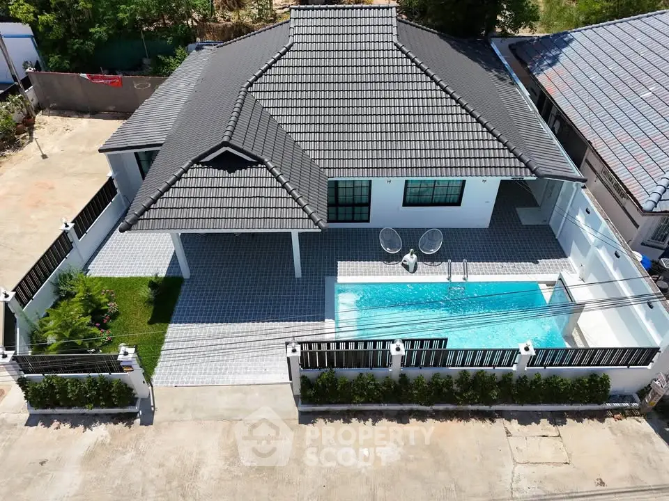 Stunning aerial view of modern house with private pool and landscaped garden.