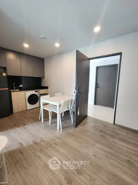 Modern kitchen with dining area and washing machine in sleek apartment