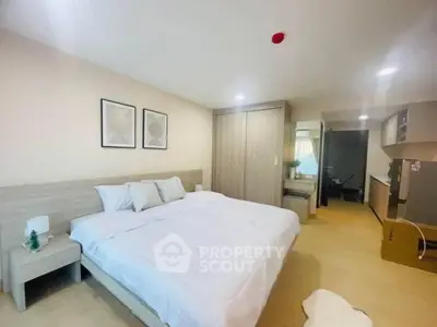 Spacious modern bedroom with cozy decor and ample storage in a stylish apartment.