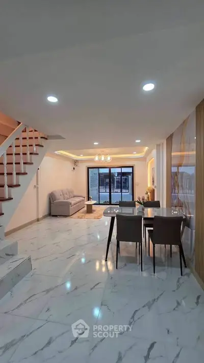 Spacious modern living room with elegant marble flooring and stylish dining area, perfect for family gatherings.