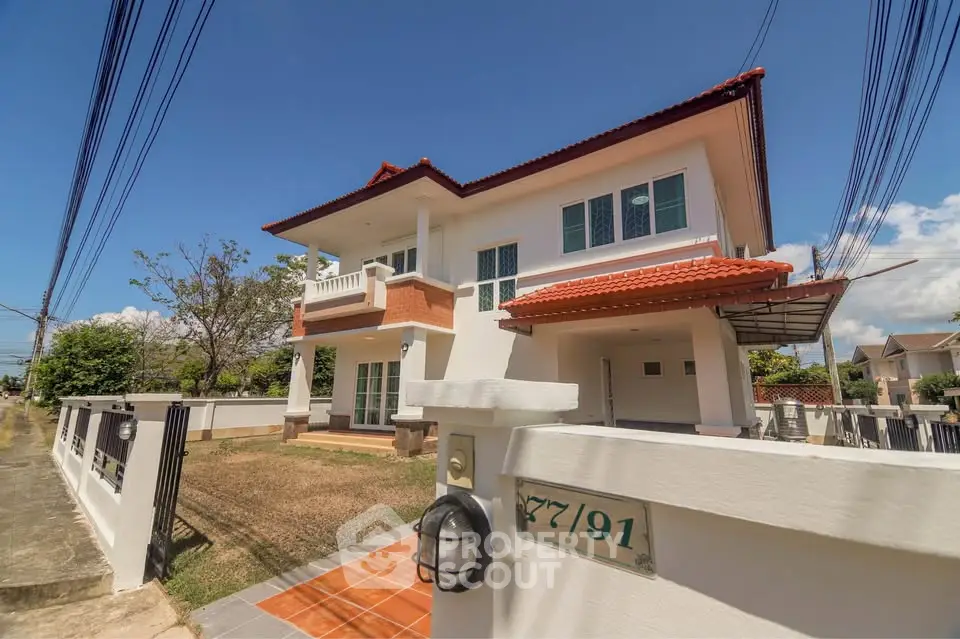 Stunning two-story house with red-tiled roof and spacious yard in a serene neighborhood.