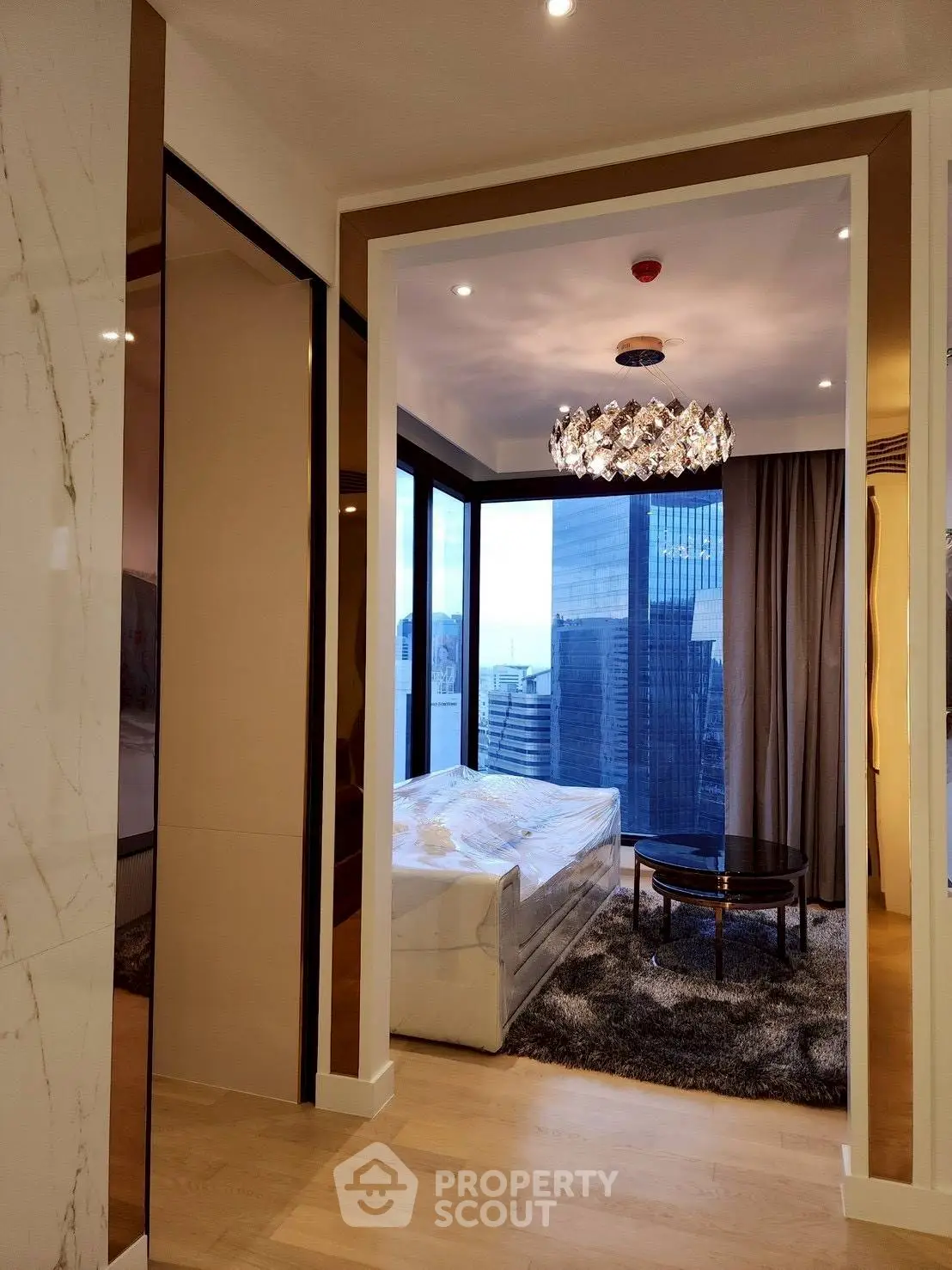 Luxurious modern living room with stunning city view and elegant chandelier