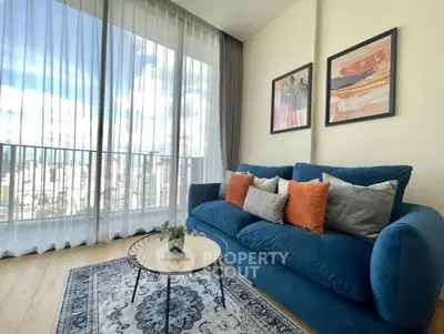 Stylish living room with blue sofa, modern decor, and panoramic city view.