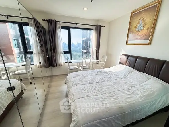 Bright bedroom with large windows and scenic view, featuring a cozy bed and elegant decor.