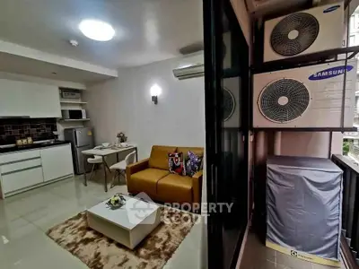 Modern open-layout living room with compact kitchen and balcony air conditioning units.
