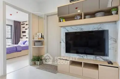 Modern living room with stylish TV unit and view into a cozy bedroom.