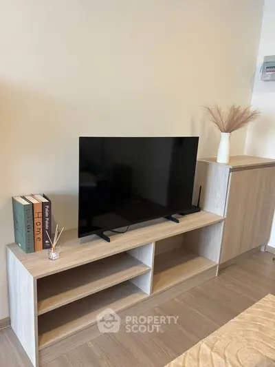 Modern living room with sleek TV stand and decorative elements, perfect for cozy home entertainment.