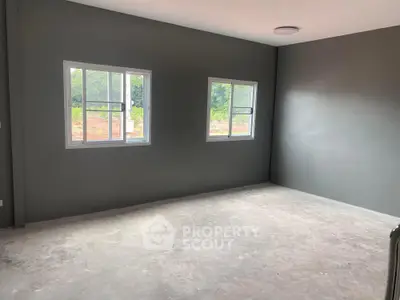 Spacious unfurnished room with large windows and natural light