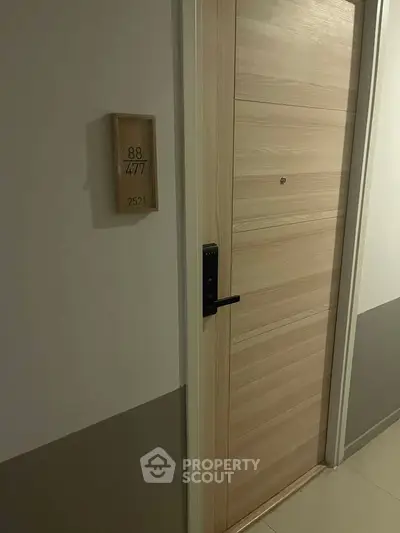 Modern apartment entrance with sleek wooden door and digital lock, showcasing secure and stylish living.