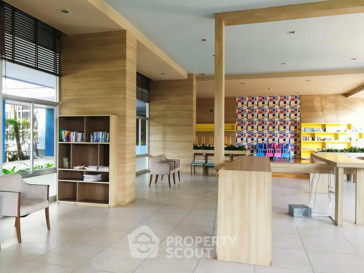 Modern library with stylish wooden shelves and cozy seating in a bright, open space.