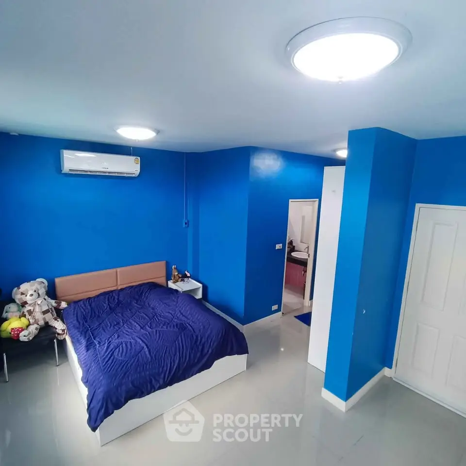 Spacious blue-themed bedroom with modern lighting and air conditioning, perfect for comfort and relaxation.