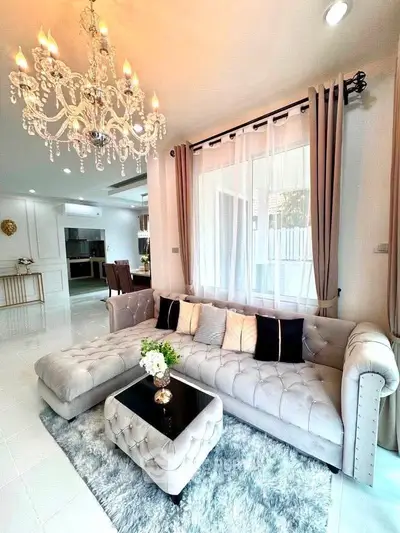 Luxurious living room with elegant chandelier and plush sectional sofa in modern home.