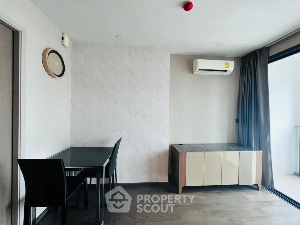 Modern minimalist living room with sleek furniture and air conditioning, featuring a stylish clock on the wall.