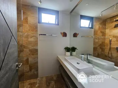 Luxurious modern bathroom with elegant fixtures and natural stone tiles