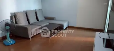 Modern living room with sleek gray sofa and wooden flooring, perfect for relaxation.