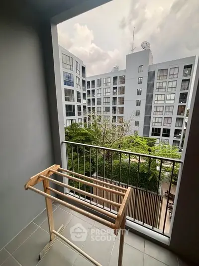 Modern apartment balcony with city view and drying rack, perfect for urban living.