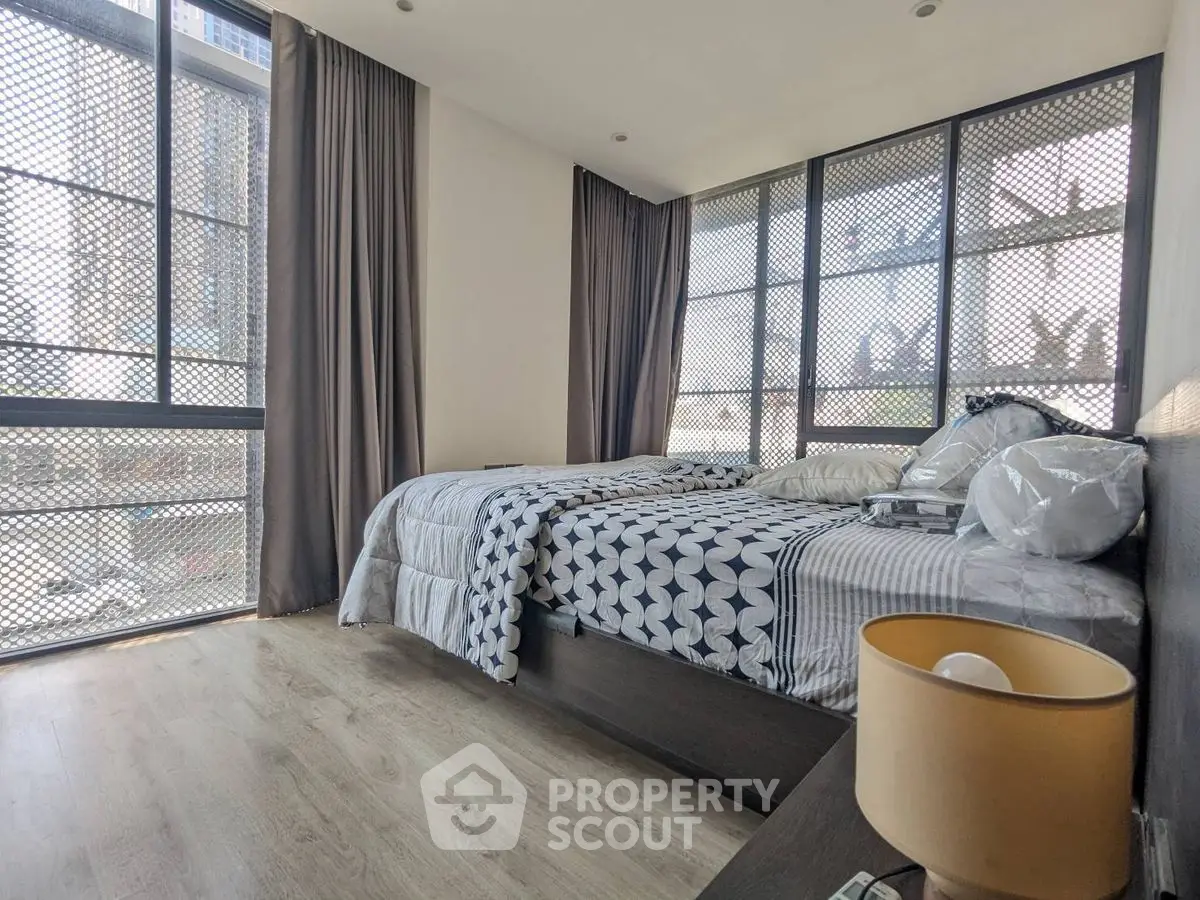 Modern bedroom with large windows and stylish decor in urban apartment